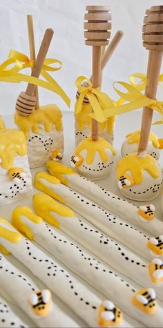 some yellow and white decorated desserts on sticks