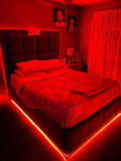 a bed with red lights on it in a room that looks like someone's bedroom