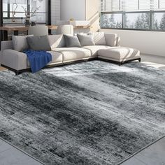 a living room with a large gray rug on the floor