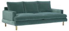 a green velvet couch with gold legs