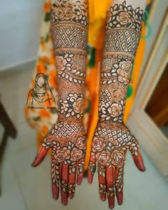 a woman's hands with henna tattoos on her arm and hand, showing the intricate