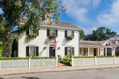 a white house with black shutters and an american flag