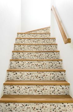 a set of stairs leading up to the top floor in a home with white walls and wood handrails