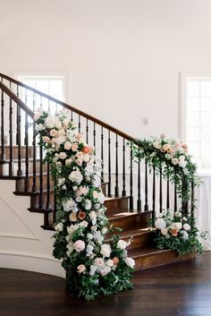 a staircase decorated with flowers and greenery