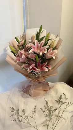 a bouquet of flowers sitting on top of a white cloth covered table next to a mirror