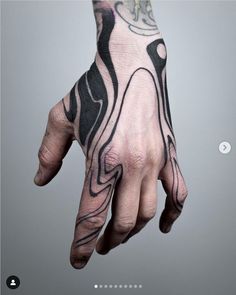 a man's hand with black and white tattoos on it