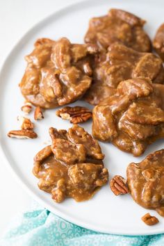 some pecans are on a white plate with caramel glaze and pecans