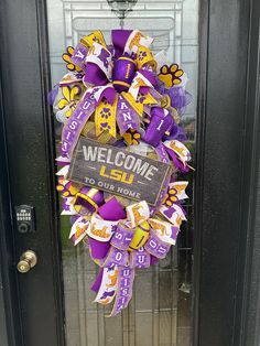 a purple and yellow welcome to lsu wreath