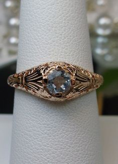 Natural Blue Topaz Ring Description Floral Wedding Design#154 Custom This is a Victorian/Edwardian reproduction wedding ring in 10K solid rose gold filigree with a natural blue topaz gemstone solitaire. This full cut round cut blue topaz is 4mm in diameter. The inside of the band is marked 10K for gold. Notice the beautiful floral design of the gold filigree setting. This is a lovely rendition of an Antique filigree ring, and it is ready to wear. A gift ring box is included and all rings are shi Leaf Filigree, Mystic Fire Topaz, Filigree Pendant Necklace, Ring Rosegold, Antique Filigree, Order Design, Antique Ring, Filigree Pendant, Sterling Silver Filigree