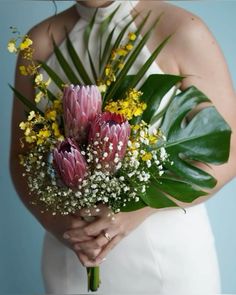 a woman holding a bouquet of flowers in her hands