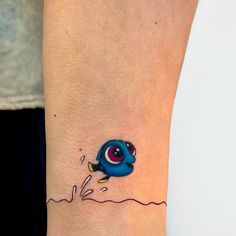 a small tattoo on the ankle of a woman's leg with an evil looking fish coming out of water