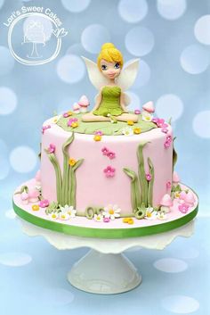 a cake with a fairy sitting on top of it