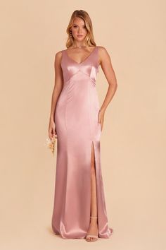 a woman in a long pink dress with a slit down the side and her hand on her hip