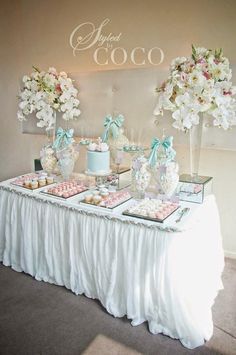 the dessert table is decorated with white flowers