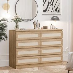 a dresser with drawers and mirrors on the wall in front of a chair next to a potted plant