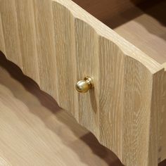 a close up of a wooden drawer with brass knobs