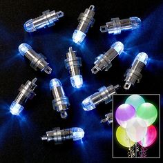 several different types of light up balloons on a black surface with blue lights around them