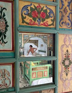 an artisticly painted room with a doll in the window