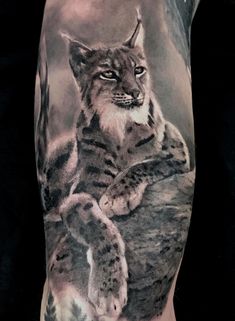 a man's arm with a tattoo of a cat and cub on the side