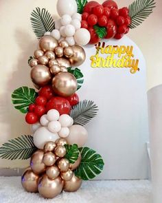 a birthday cake made out of balloons and palm leaves with the words happy birthday on it