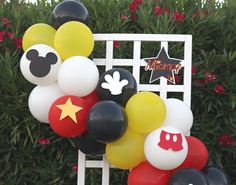 a mickey mouse balloon arch is decorated with balloons