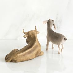 two figurines sitting on top of a white table