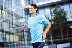 a young man running in front of a building with his hands behind his back as if he were listening to music