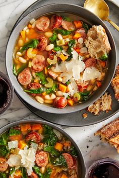 two bowls filled with soup next to toasted bread on top of a marble counter