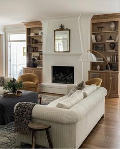 a living room filled with furniture and a fire place in the middle of a room