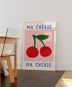 a framed poster on the floor in front of a chair and table with a vase