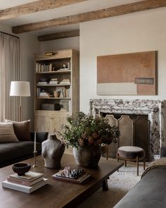 a living room filled with furniture and a fire place in front of a fireplace covered in books