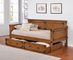 a day bed with drawers underneath it in a room that has hardwood floors and white walls