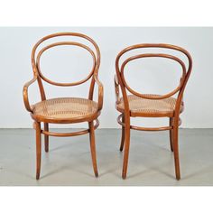 a pair of wooden chairs sitting next to each other