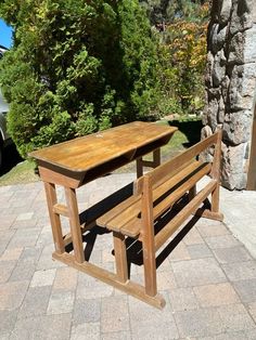 a wooden bench sitting next to a stone wall