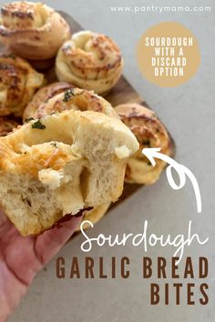 someone is holding some bread in their hand with the words sourdough garlic bread bites