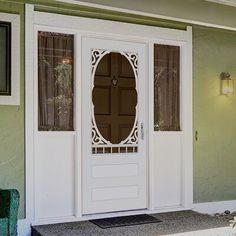 a white front door with two sidelights and a mirror on the wall above it