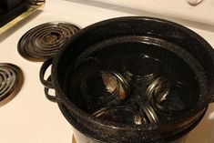 an old fashioned pot is sitting on the stove with two burners next to it