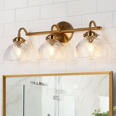 a bathroom vanity with three lights and a mirror