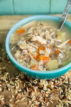 a blue bowl filled with chicken and rice soup