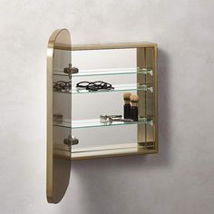 a mirror mounted to the side of a wall next to a hair brush and other items