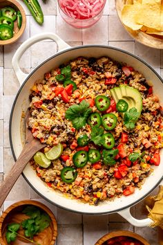 mexican rice and vegetables in a skillet with tortilla chips on the side