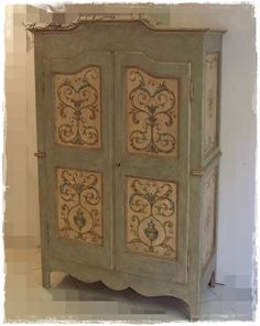 an old wooden cabinet with ornate designs painted on it