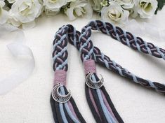 two braided leashes with rings and flowers in the background