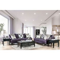 a living room filled with purple couches and chairs in front of large open windows