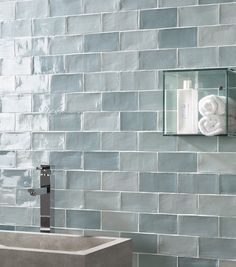 a bathroom with a sink, mirror and soap dispenser on the wall