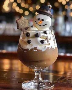 a glass filled with chocolate pudding and a snowman in the middle, sitting on top of a bar