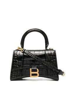 Black leather Hourglass top-handle tote bag from Balenciaga featuring crocodile effect, gold-tone logo plaque, single rounded top handle, adjustable detachable shoulder strap, foldover top with magnetic fastening, main compartment, internal logo stamp and internal zip pocket. | Balenciaga Hourglass top-handle tote bag Tas Hermes, Sacs Tote Bags, Balenciaga Leather, Luxury Purses, Balenciaga Bag, Black Leather Handbags, Black Shoulder Bag, Logo Stamp, Black Tote Bag