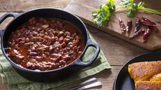 a bowl of chili next to two slices of bread