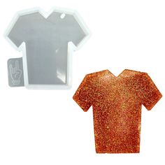 an orange glittered t - shirt shaped object next to a white and gray mirror