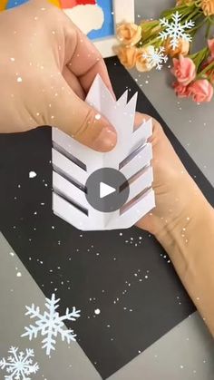 someone is making a snowflake out of paper